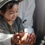 A man teaching his child to pray